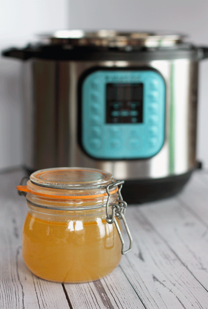 Jar of Instant Pot Chicken Stock with Instant Pot in background