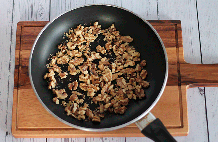 walnuts toasting in a frying pan
