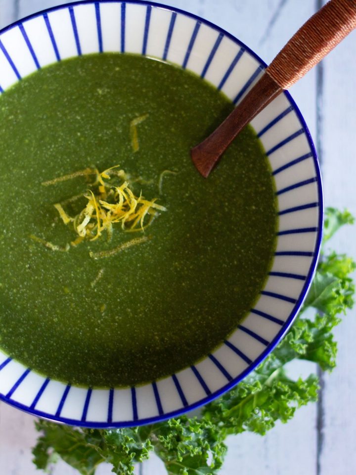 bowl of green soup topped with lemon zest