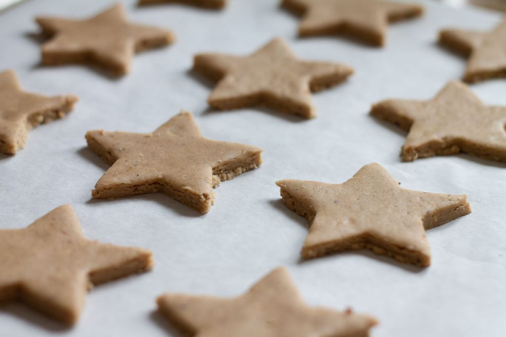 Spiced Christmas star biscuits on a baking sheet