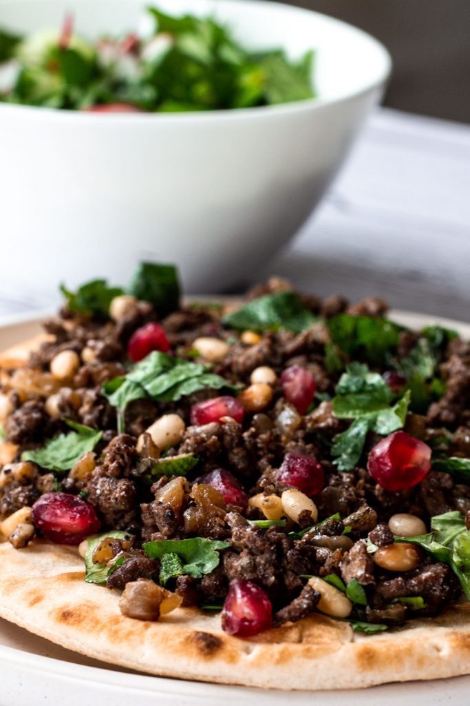 lamb mince flatbread with salad bowl in the background