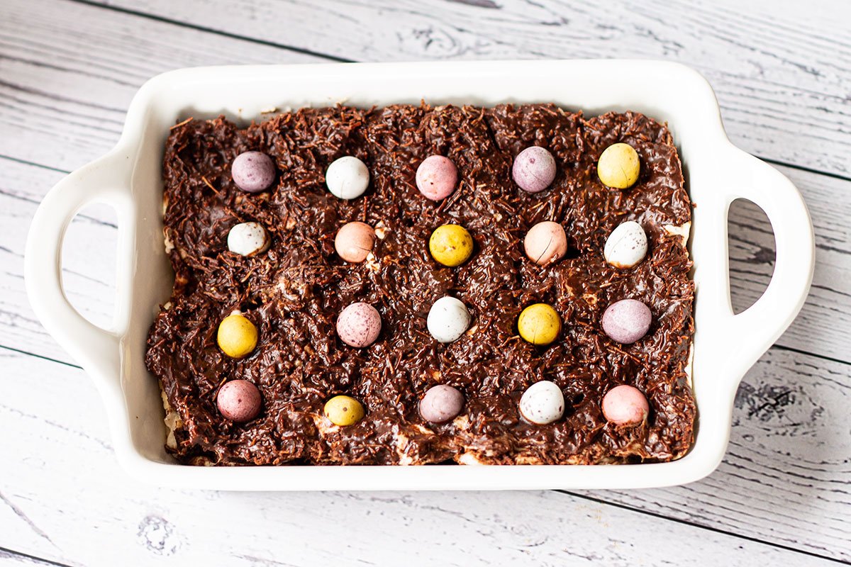Mini egg brownies in a baking dish with the shredded wheat and Mini Egg topping.