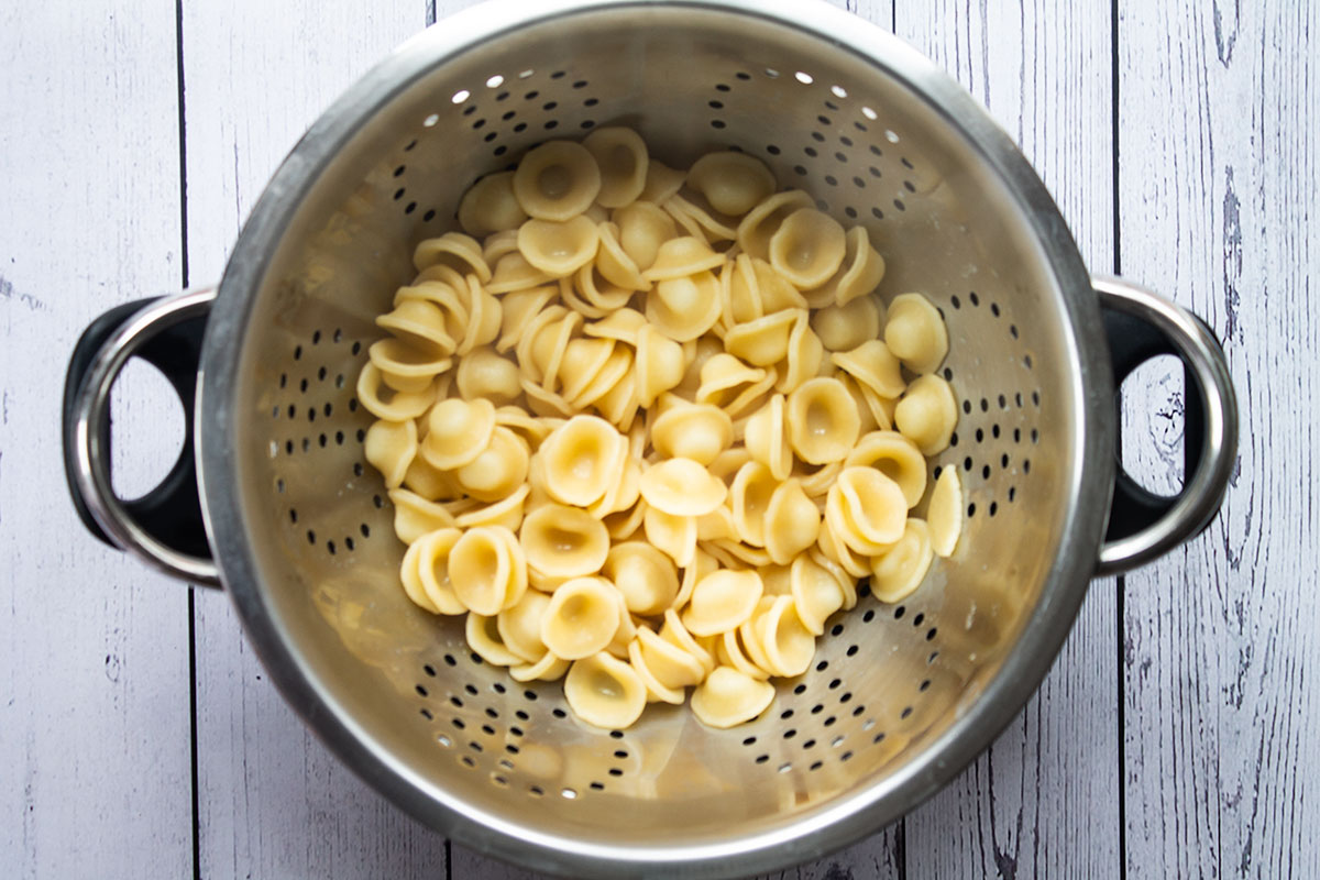 Cooked orecchiette pasta in a colander.