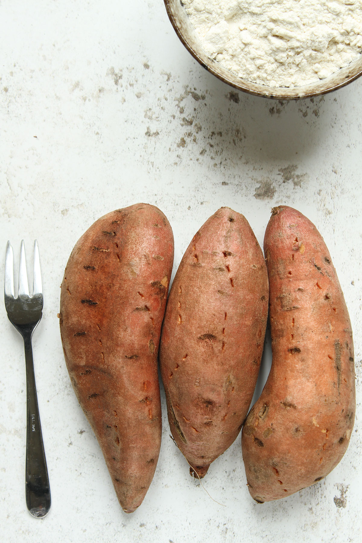 The sweet potatoes ready for cooking and a bowl of flour.