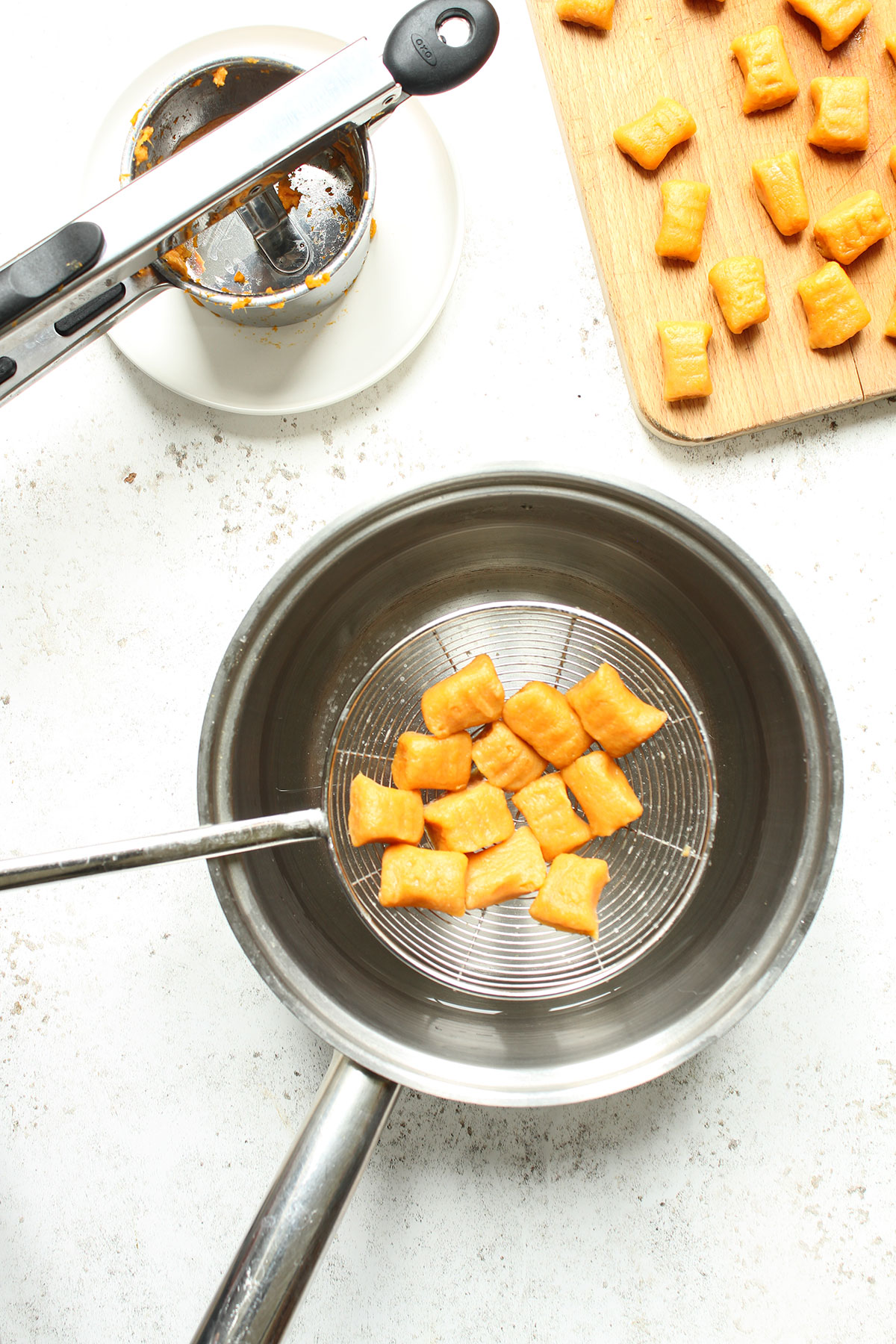 Cooking the formed gnocchi in boiling salted water.