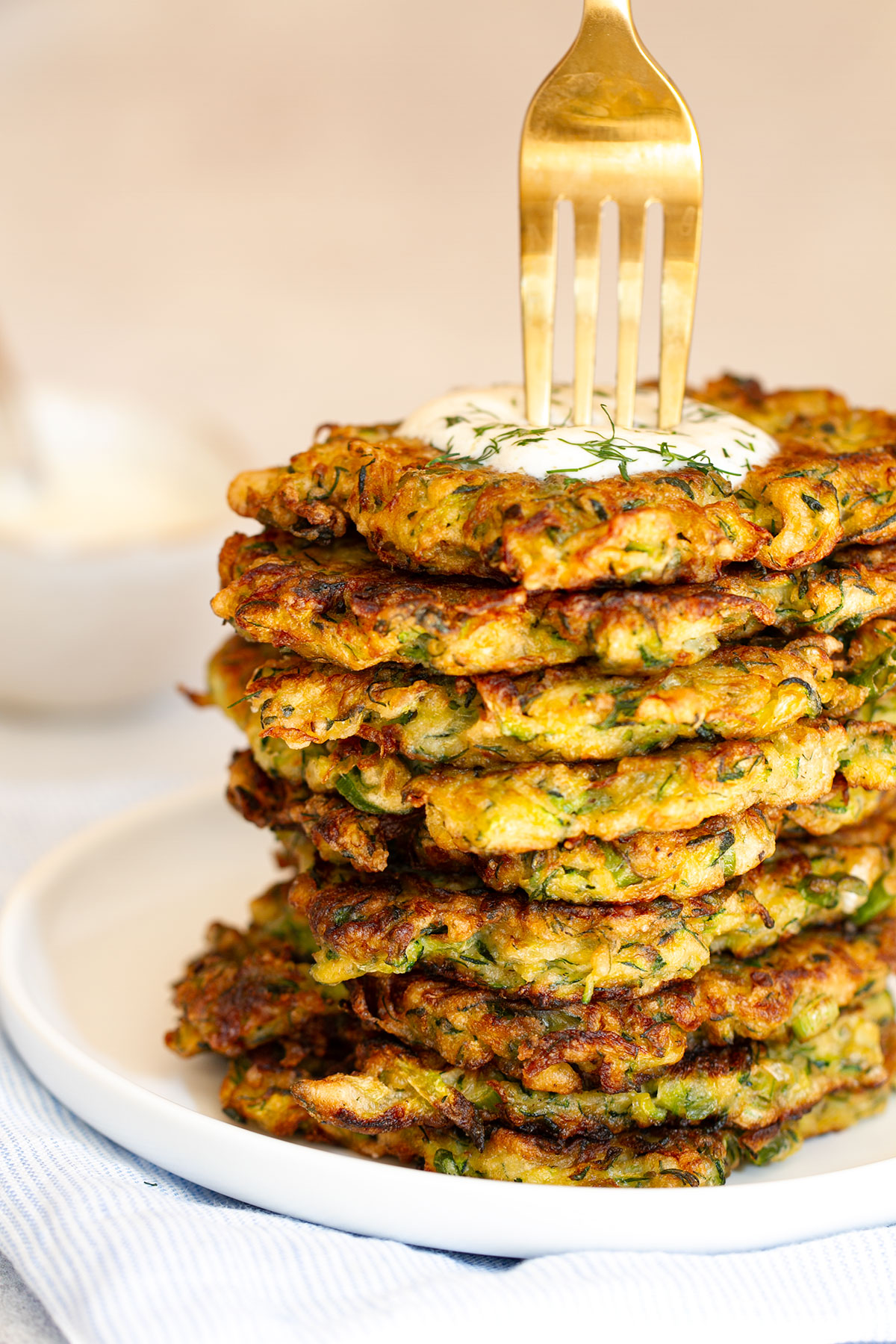 The cooked zucchini pancakes on a white plate.