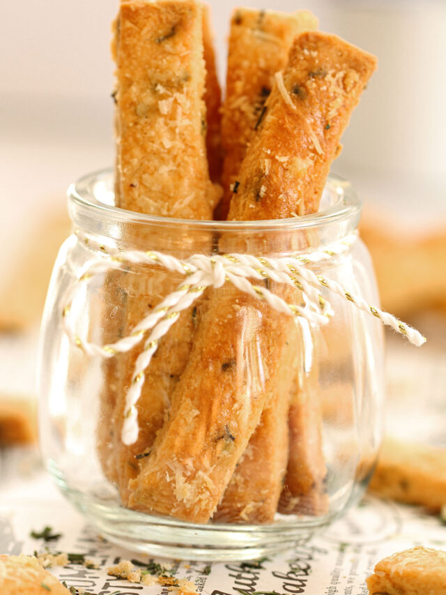 Cheese Straws standing in a glass jar.