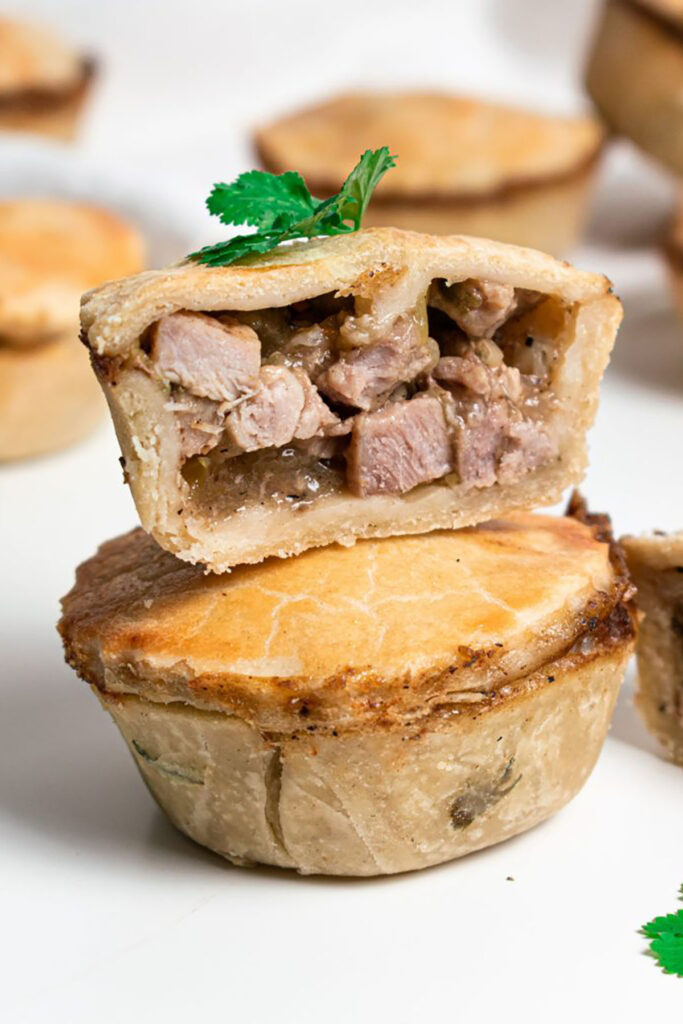 One pork pie on top of another chopped in half.