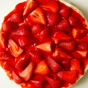 No Bake Strawberry Cheesecake in a white dish topped with fresh strawberries ready for serving.