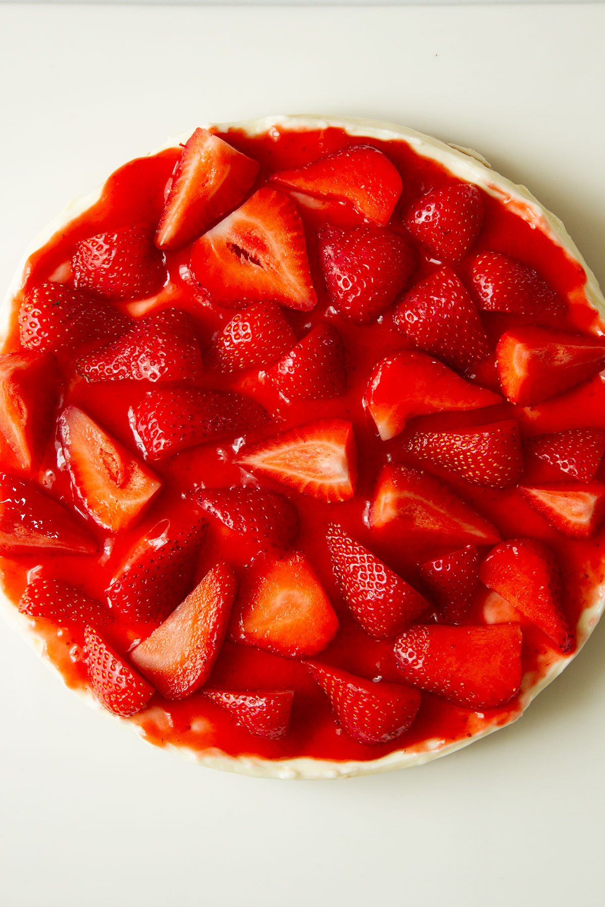 No Bake Strawberry Cheesecake in a white dish topped with fresh strawberries ready for serving.
