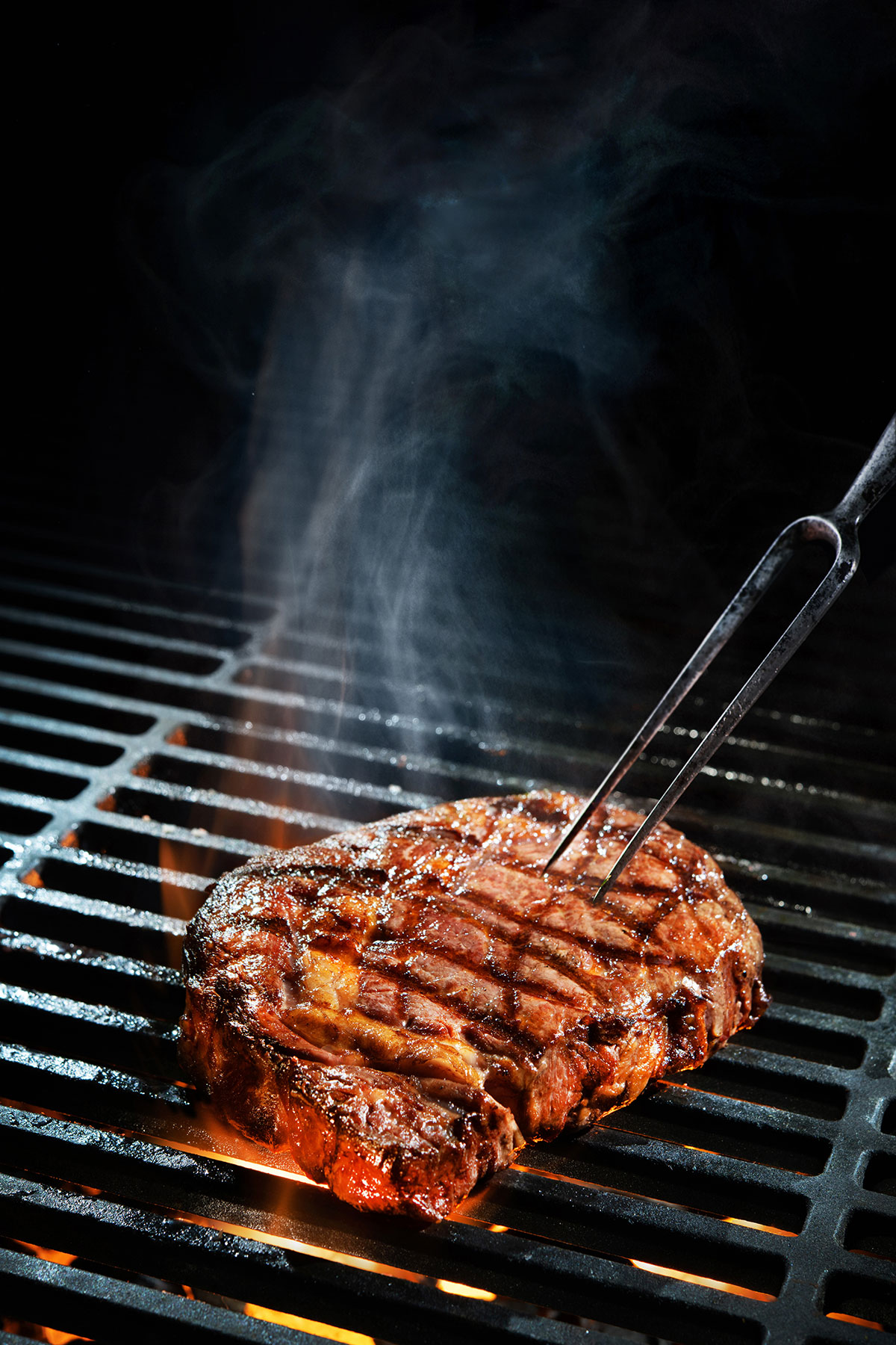 A charred steak on a grill.