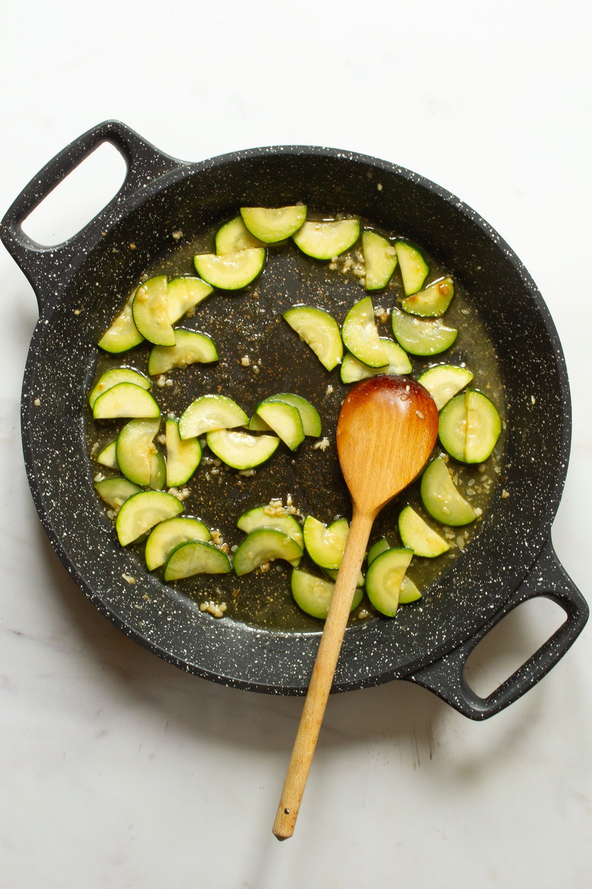 Frying the zucchini/courgette until it starts to brown in a dark coloured pan.