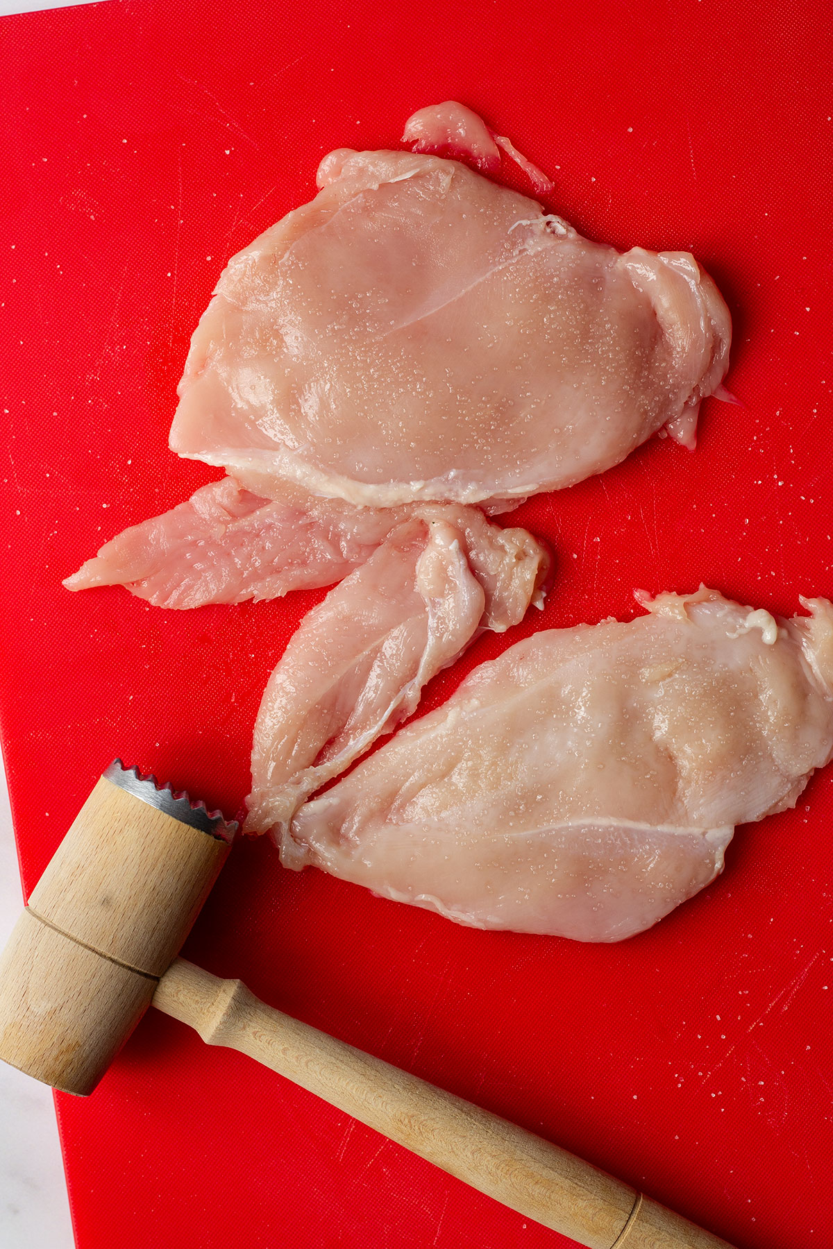 Bashing the chicken with a meat tenderiser until ¼ inch thick and seasoned with salt on both sides.
