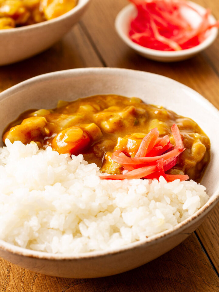 A serving of Japanese Curry with chicken, topped with pickled red ginger.