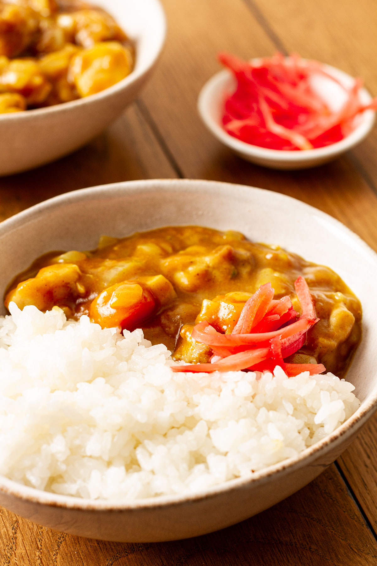 A serving of Japanese Curry with chicken topped with pickled red ginger.