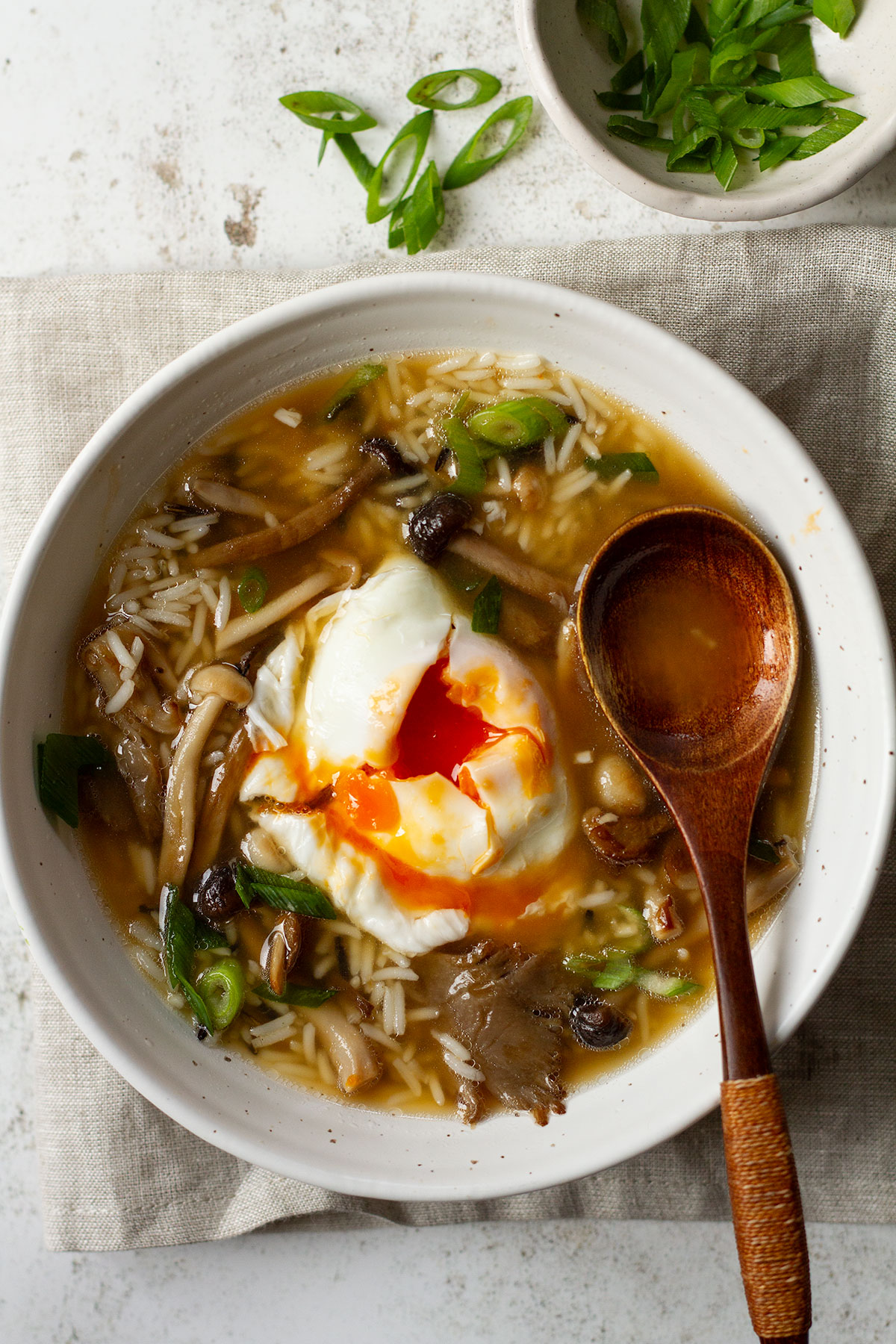 A bowl of miso mushroom soup with rice and a poached egg.
