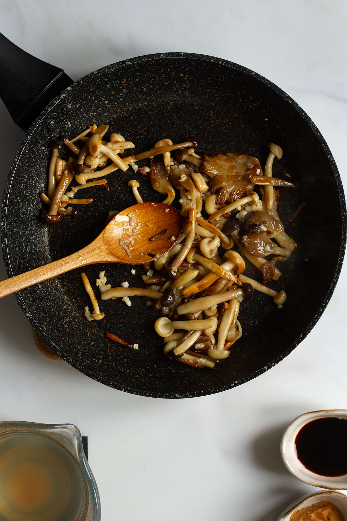 A skillet of sauteed mushrooms on a white background.