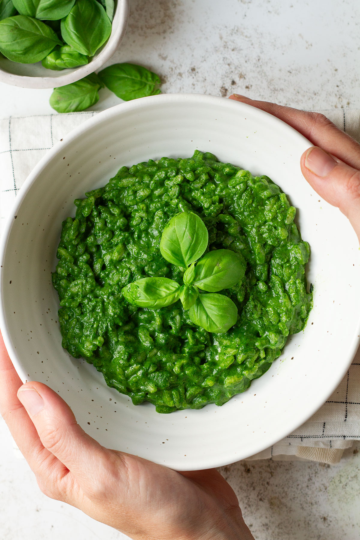 Risotto Verde with a basil garnish served in a white bowl.
