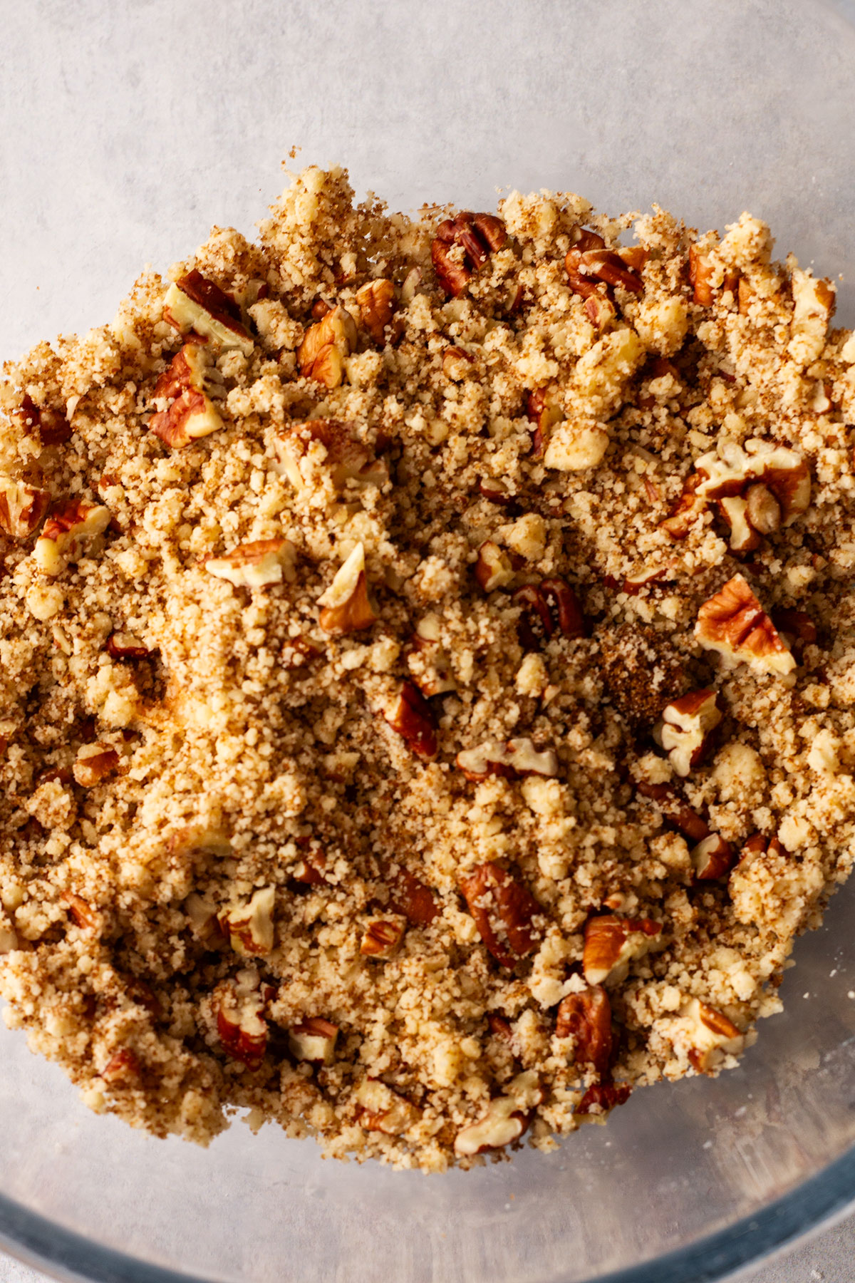 The butter, flour, sugar and pecans mixed together in a glass bowl..