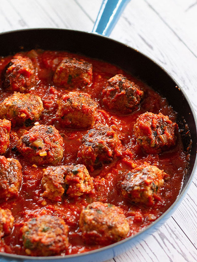 Meatballs in tomato sauce in a skillet.