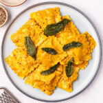 A serving of pumpkin ravioli on a white plate.