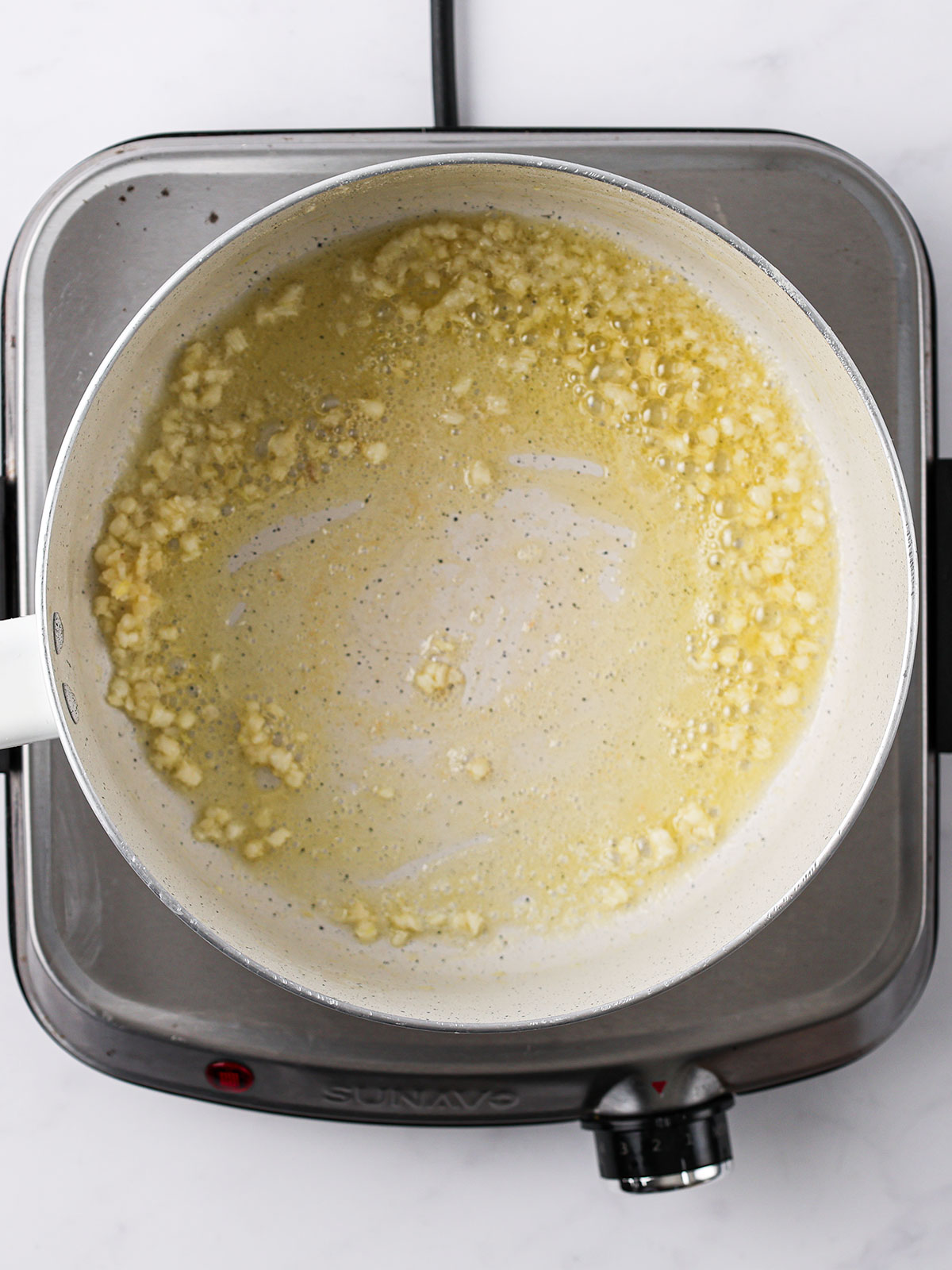 Melt the butter in a large pot over medium heat, add minced garlic, and sauté until fragrant. In a white bowl.