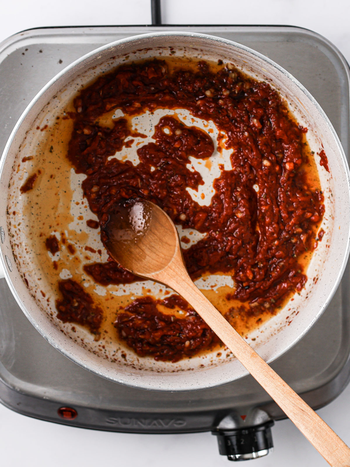 Stir in the tomato puree, oregano, sugar, and balsamic vinegar. Cook for about 1 minute until it forms a paste. In a white bowl.