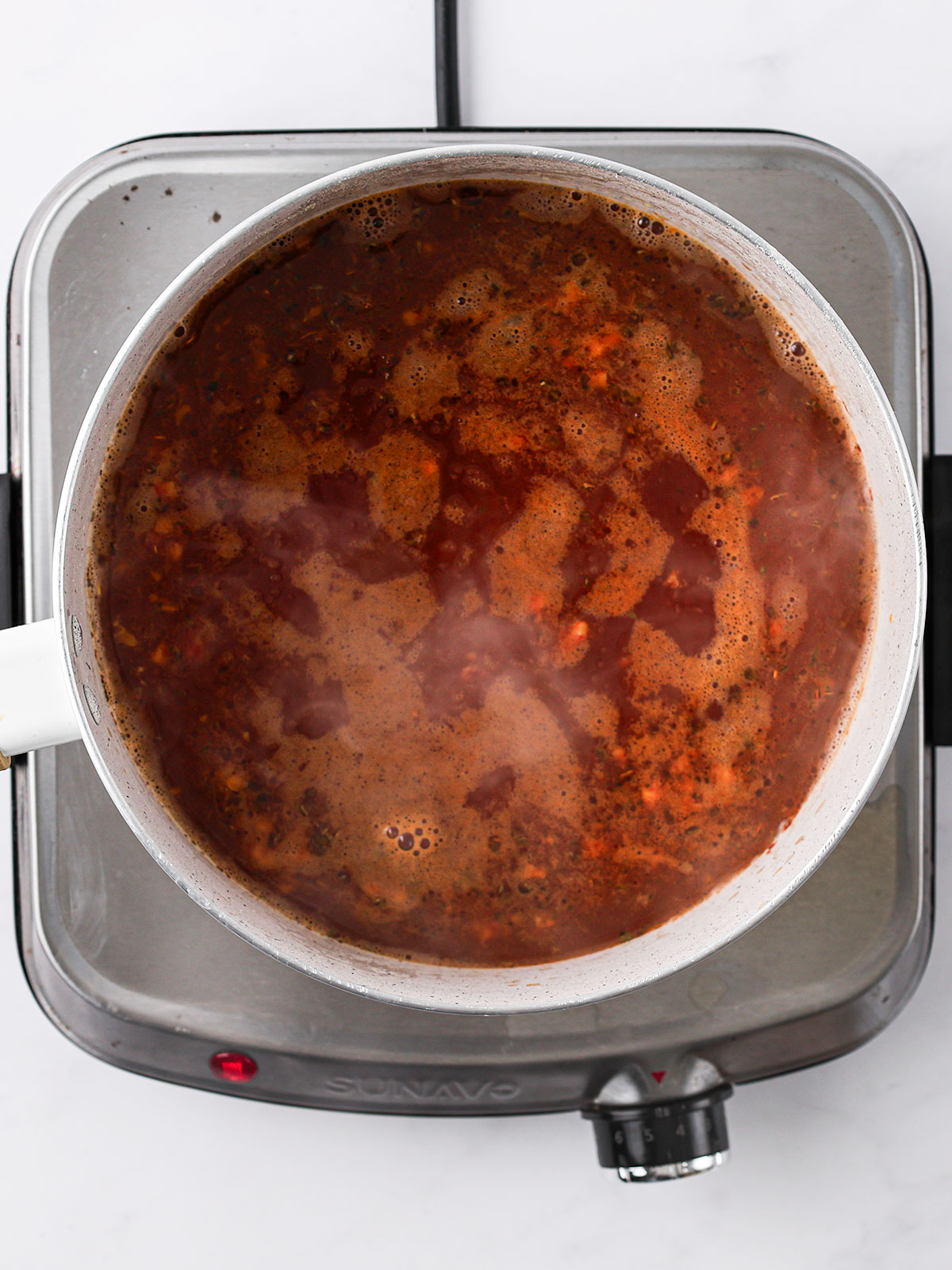Pour in the stock, stir to dissolve the tomato mixture, raise heat, and bring to a boil. In a white bowl.